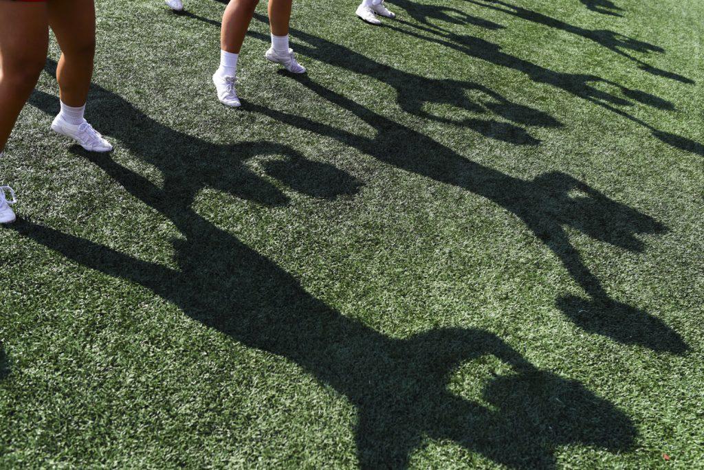 Shadows of WKU cheerleaders dance on the sideline turf as Western Kentucky University takes on Vanderbilt.