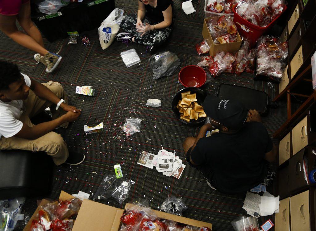 Louisville senior and director Dexter Crowdus and cast members prepare the prop bags for the final night. Each audience member was given a bag to have during the show. During the show, members from the audience threw items at the screen. Photo by Mhari Shaw.