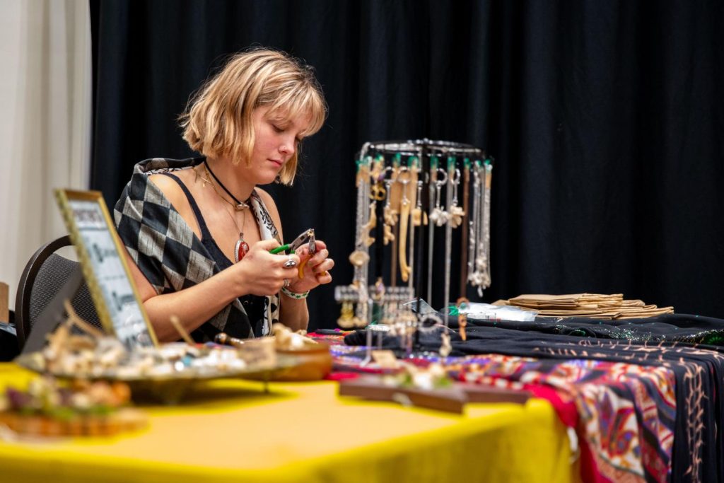 Rylynn Strange, 17, owner of Cryptic Creationzz makes jewelry at her booth during the Punk Rock Flea Market at Sloan Convention Center on Saturday, Aug. 30, 2025.