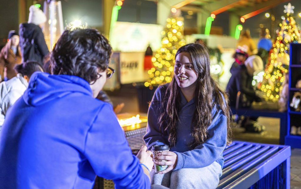 Baylee Thornton and JD Lightfoot sip on hot chocolate while having a conversation at SoKY Ice Rink located in Downtown Bowling Green on Sunday, Dec. 7. (Photo by Bradi Hawkins)